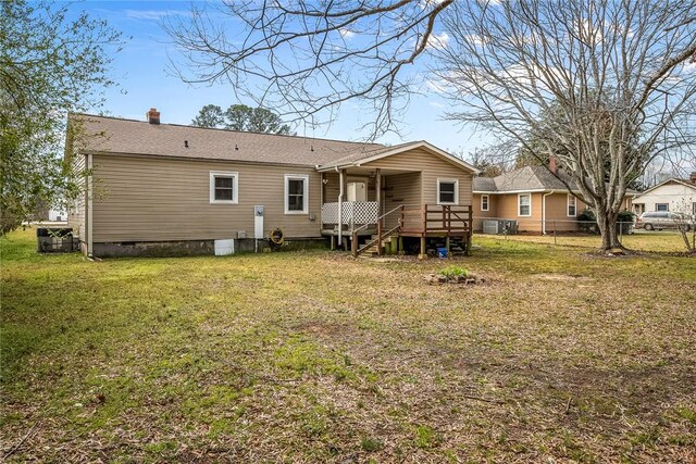 back of house featuring a lawn, a deck, fence, crawl space, and a chimney