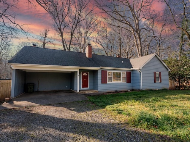 ranch-style house featuring a chimney, a shingled roof, a yard, and dirt driveway