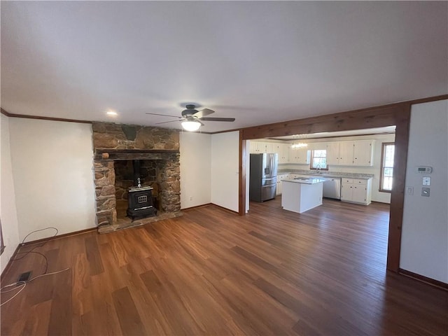 236 Issaqueena Dr, Central, SC 29630 - unfurnished living room with a wood stove, ceiling fan, dark wood finished floors, and crown molding