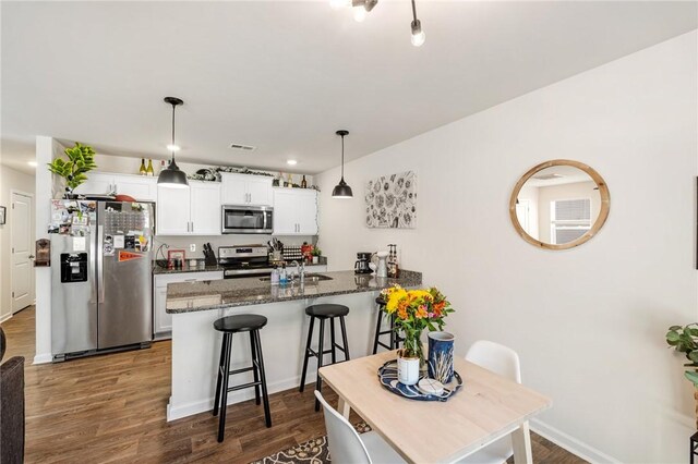 511 Oakmont Valley Trl, Seneca, SC 29678 - kitchen with white cabinets, appliances with stainless steel finishes, a kitchen breakfast bar, a peninsula, and dark wood-type flooring
