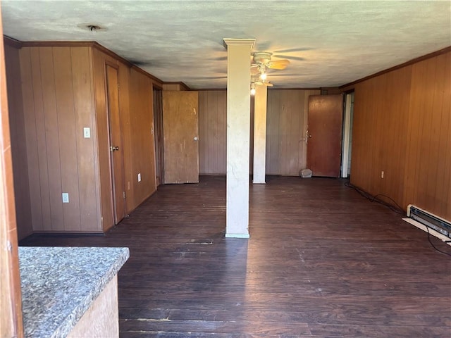 interior space featuring ornamental molding, wood finished floors, a ceiling fan, and wood walls