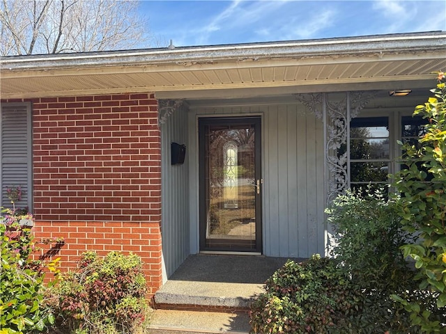 doorway to property with brick siding