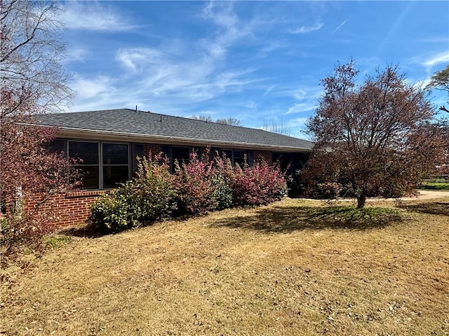 view of side of property with a yard and brick siding