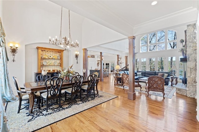 136 Blue Water Trl, Salem, SC 29676 - dining space featuring light wood finished floors, crown molding, decorative columns, a towering ceiling, and a notable chandelier