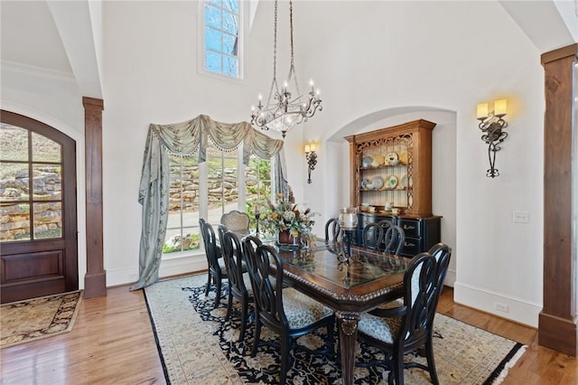 136 Blue Water Trl, Salem, SC 29676 - dining area featuring a towering ceiling, arched walkways, light wood-style floors, baseboards, and a chandelier