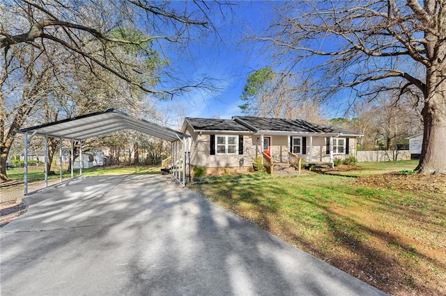 view of front of house featuring a detached carport, fence, a front lawn, and driveway