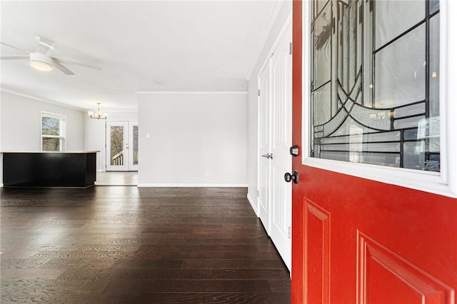 entryway featuring wood finished floors, ceiling fan with notable chandelier, baseboards, and ornamental molding