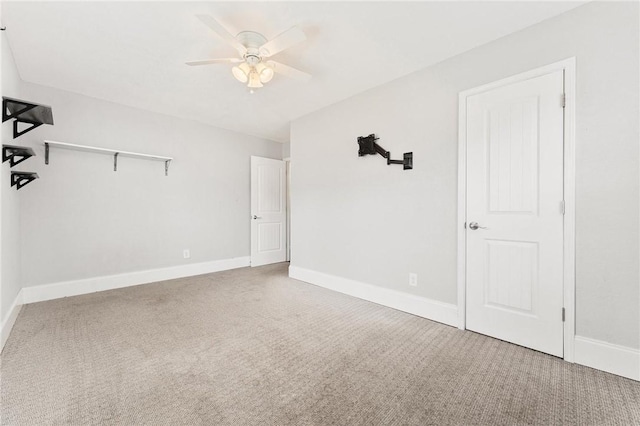 interior space featuring ceiling fan, baseboards, and carpet floors
