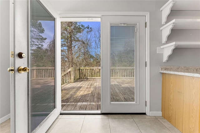 doorway featuring baseboards and light tile patterned flooring