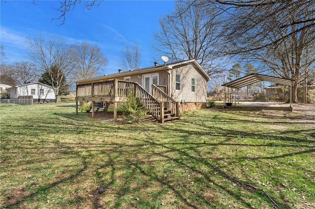 rear view of house with a carport, stairway, a lawn, and a wooden deck