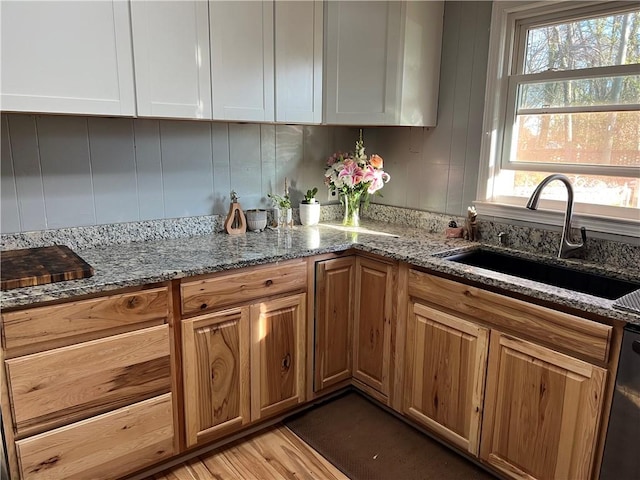 125 Victorian Dr, Anderson, SC 29625 - kitchen featuring brown cabinetry, light wood-type flooring, a sink, light stone counters, and dishwashing machine