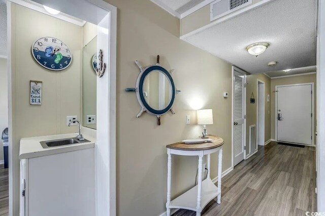 5905 S Kings Hwy Unit 138-A, Myrtle Beach, SC 29575 - hallway with visible vents, a textured ceiling, a sink, and wood finished floors