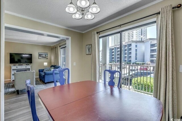 5905 S Kings Hwy Unit 138-A, Myrtle Beach, SC 29575 - dining room with a textured ceiling, crown molding, wood finished floors, and an inviting chandelier