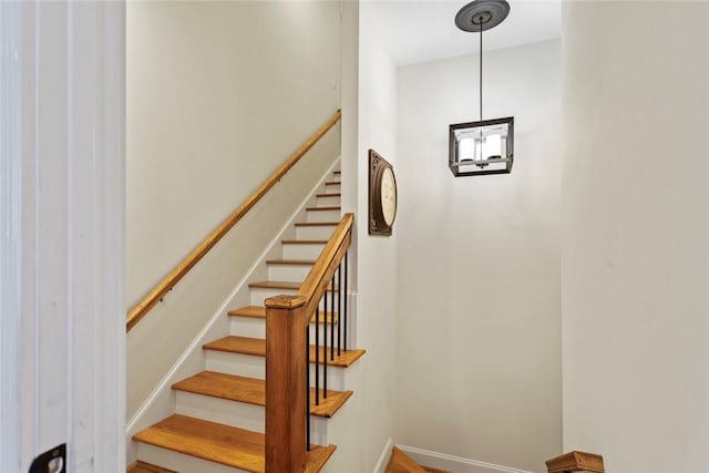 stairs featuring wood finished floors and baseboards