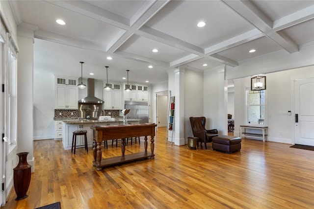 living area with beamed ceiling, light wood-style floors, coffered ceiling, baseboards, and recessed lighting