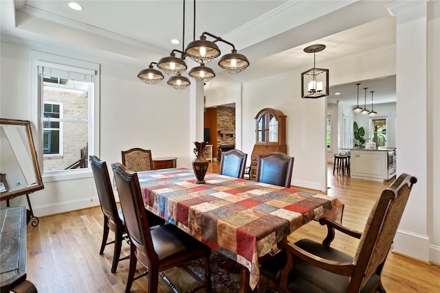 dining room with baseboards, crown molding, and light wood finished floors