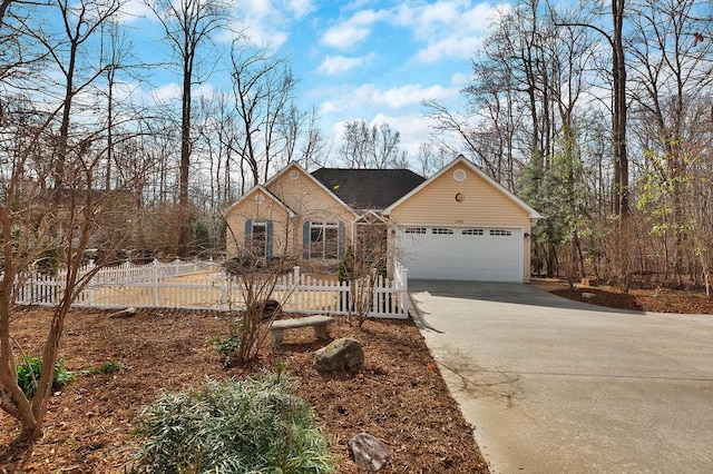 view of front of house featuring driveway, stone siding, fence, and a garage