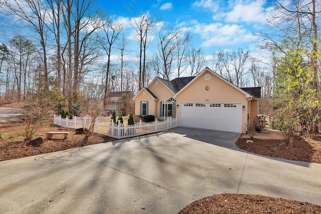 single story home with concrete driveway, a fenced front yard, and an attached garage