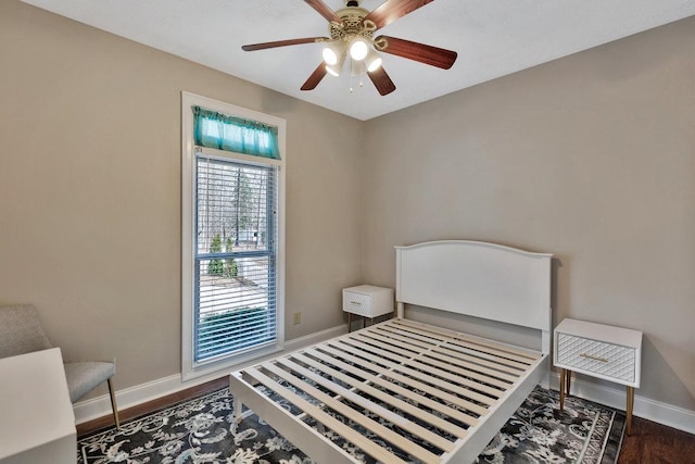 bedroom with baseboards, wood finished floors, and a ceiling fan