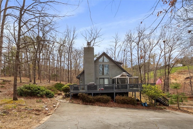 view of front facade with a chimney and a wooden deck