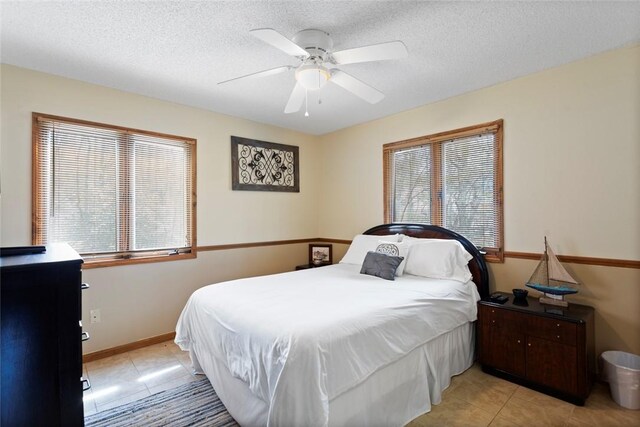 bedroom featuring a textured ceiling, multiple windows, and light tile patterned floors