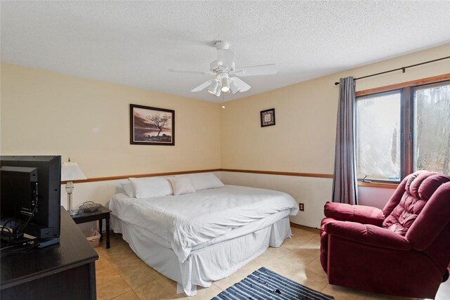 bedroom with light tile patterned flooring, ceiling fan, and a textured ceiling