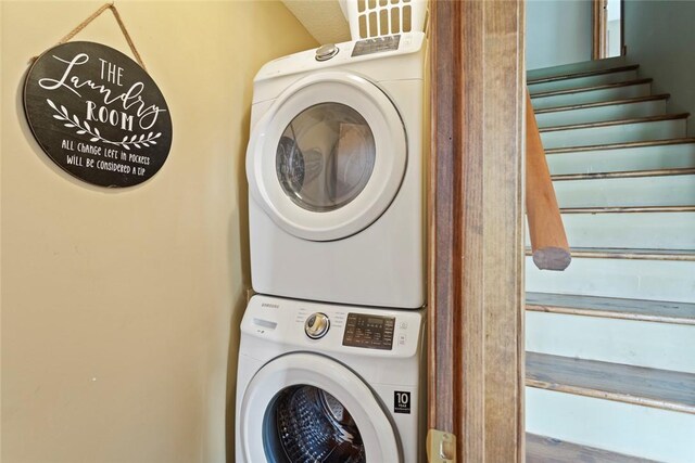 washroom featuring stacked washer and clothes dryer and laundry area