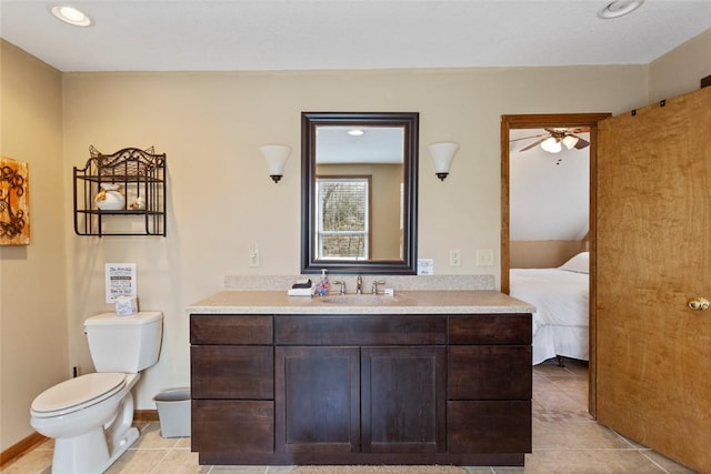 bathroom with tile patterned floors, toilet, vanity, a ceiling fan, and baseboards