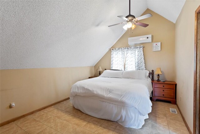 bedroom with baseboards, a textured ceiling, vaulted ceiling, and a wall unit AC