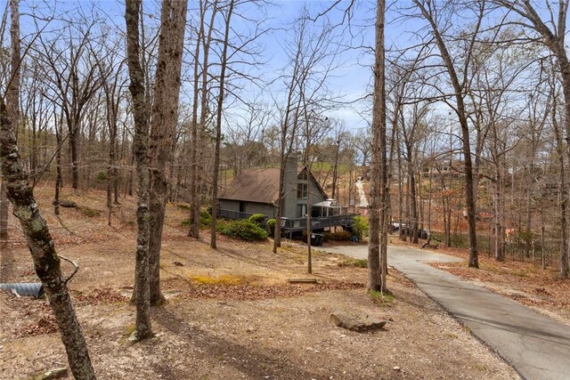 view of front of property with driveway, a deck, and a chimney