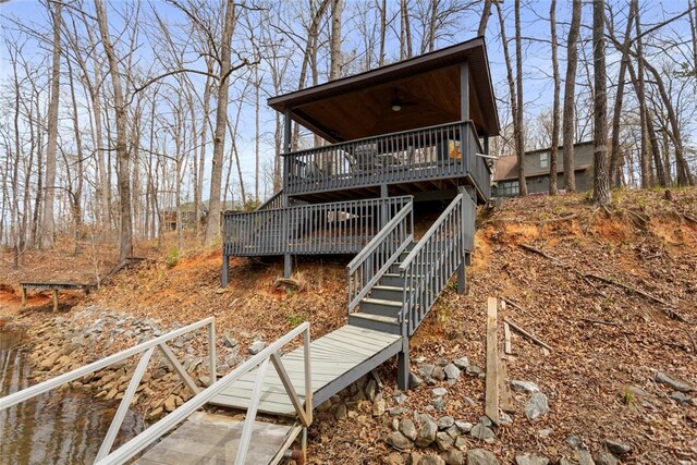 back of property with a deck and stairs
