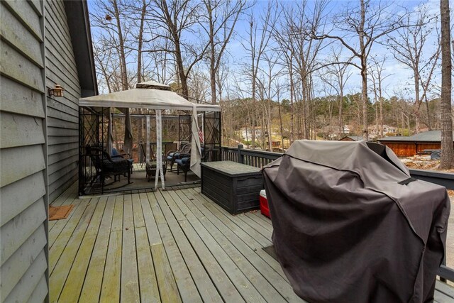 wooden deck featuring an outdoor hangout area, a gazebo, and grilling area