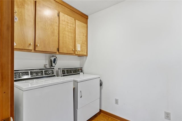 laundry room with baseboards, cabinet space, and separate washer and dryer