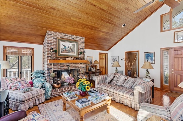living room featuring high vaulted ceiling, a fireplace, wood finished floors, and wooden ceiling
