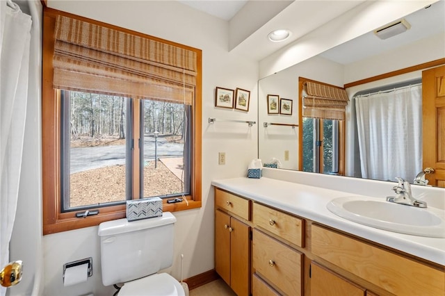bathroom featuring baseboards, toilet, and vanity