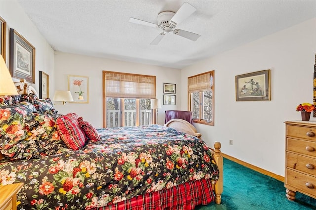carpeted bedroom with baseboards, multiple windows, ceiling fan, and a textured ceiling