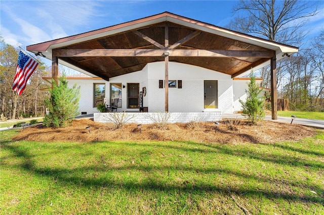 back of property with a lawn and brick siding
