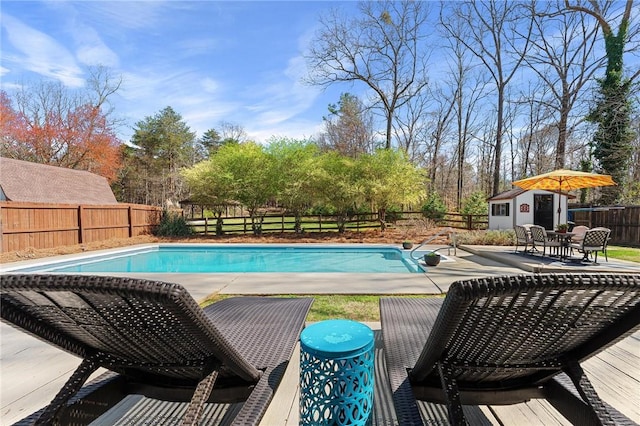 view of swimming pool with a fenced in pool, an outbuilding, a patio, and a fenced backyard