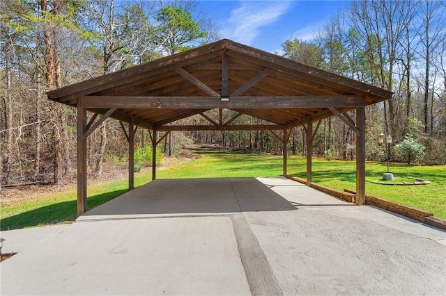view of community featuring a carport, driveway, and a yard