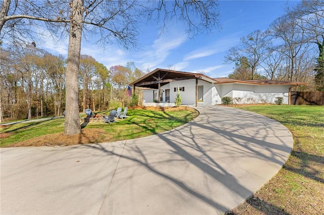 view of front of house featuring fence, a front lawn, and driveway