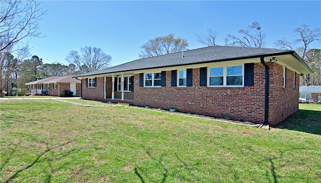 ranch-style home featuring brick siding and a front lawn