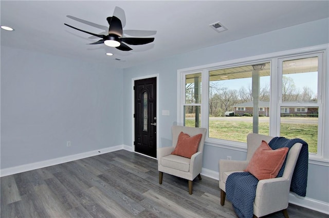 living area with plenty of natural light, dark wood-type flooring, baseboards, and visible vents