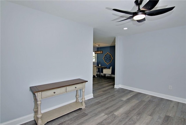 empty room with a ceiling fan, baseboards, and wood finished floors