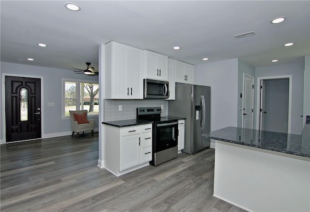 kitchen featuring backsplash, stainless steel appliances, white cabinetry, and light wood-type flooring