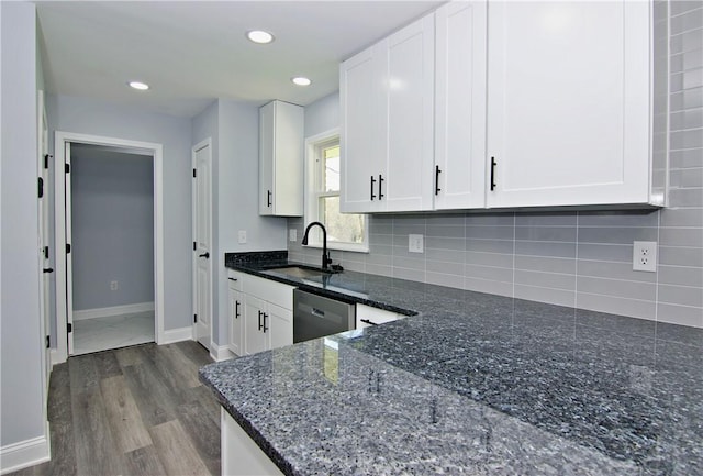 kitchen featuring decorative backsplash, white cabinetry, a sink, and dishwasher