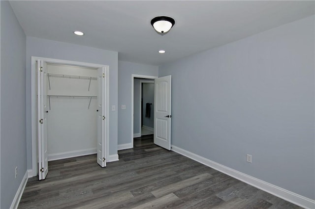 unfurnished bedroom with a closet, dark wood-style floors, baseboards, and recessed lighting