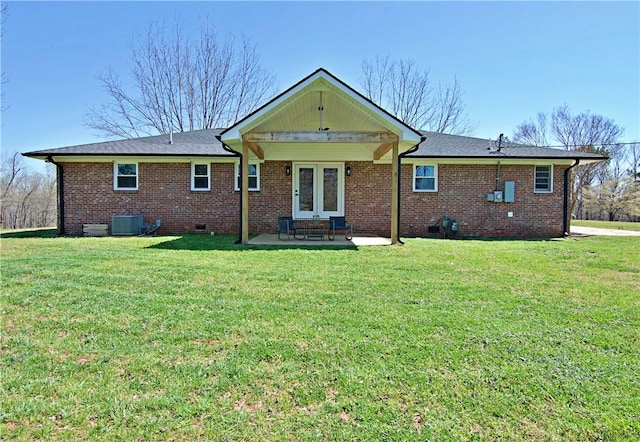 back of property with central air condition unit, a lawn, a patio, and brick siding