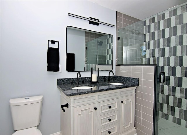 full bath featuring double vanity, a sink, toilet, and a stall shower