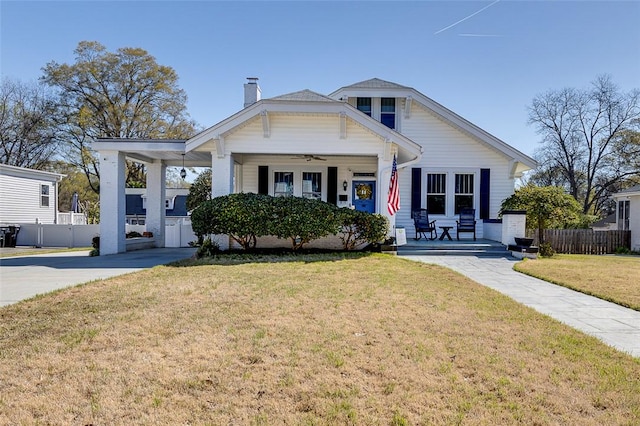 bungalow featuring a front yard, covered porch, a ceiling fan, a chimney, and fence