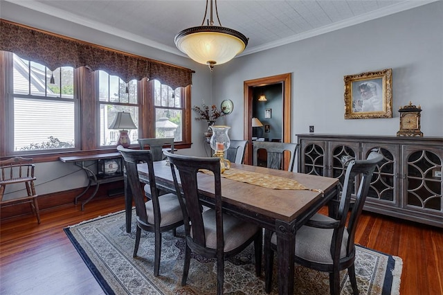dining area featuring baseboards, crown molding, and wood finished floors